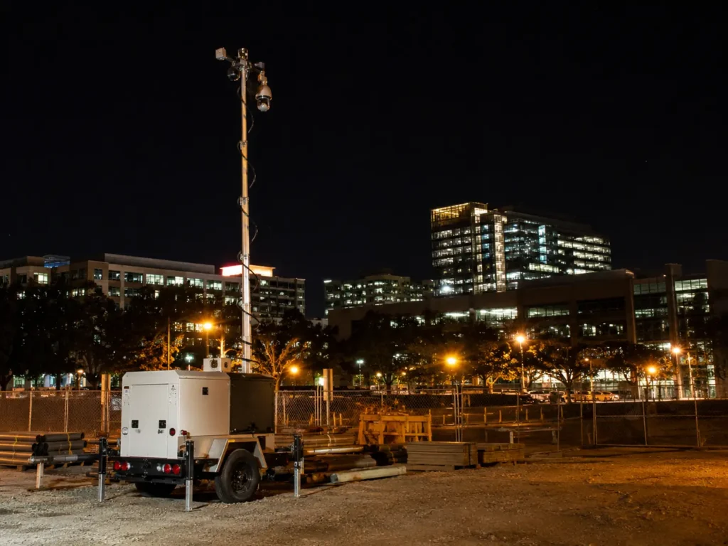 Elevated mobile surveillance trailer camera mast with PTZ security cameras monitoring a San Jose construction site at night