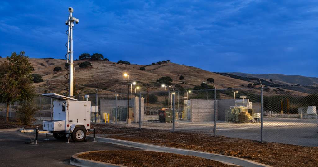 Solar mobile surveillance trailer monitoring a California shopping-center parking lot at night