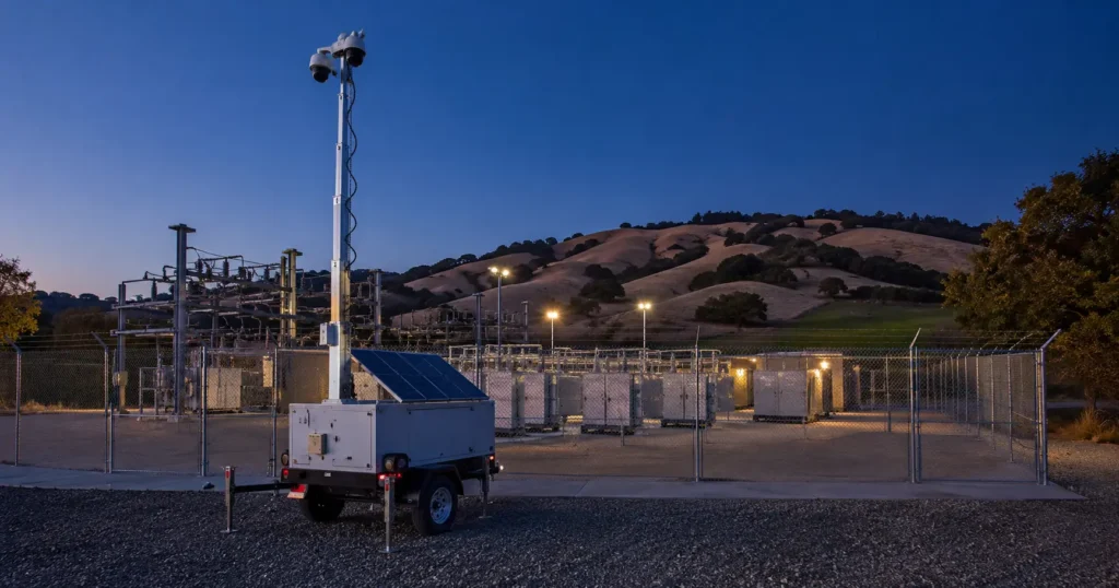Solar mobile surveillance trailer covering a California self-storage facility drive aisle at night.